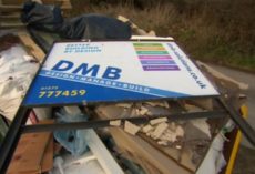 Why Use A Surveyor To Design Your Loft Conversion? DMB Solutions (building firm) sign lying discarded on a heap of rubble